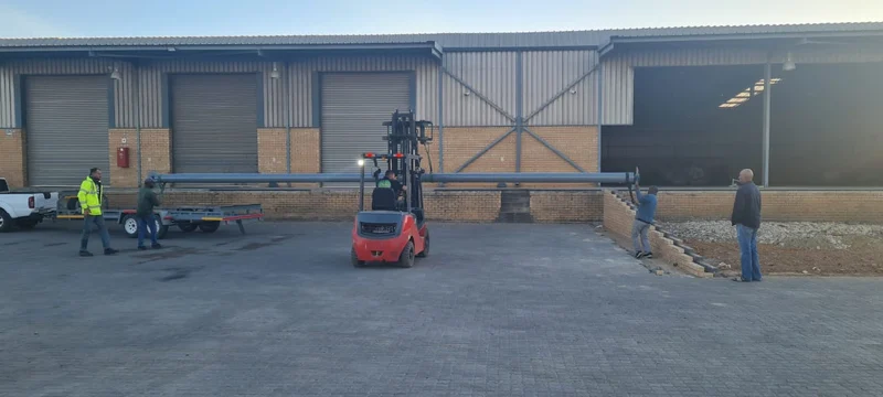 10 m barrel shaft to the loading bay: Our team guiding a 10 m barrel shaft on a forklift to a warehouse loading bay, ready to be lifted into the door brackets.