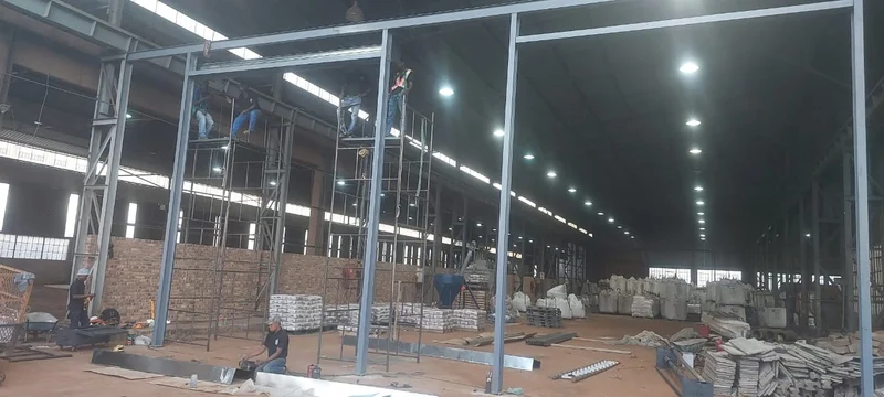 Portal frame inside a warehouse: A new structural steel portal frame erected inside an existing warehouse to form a large door opening.